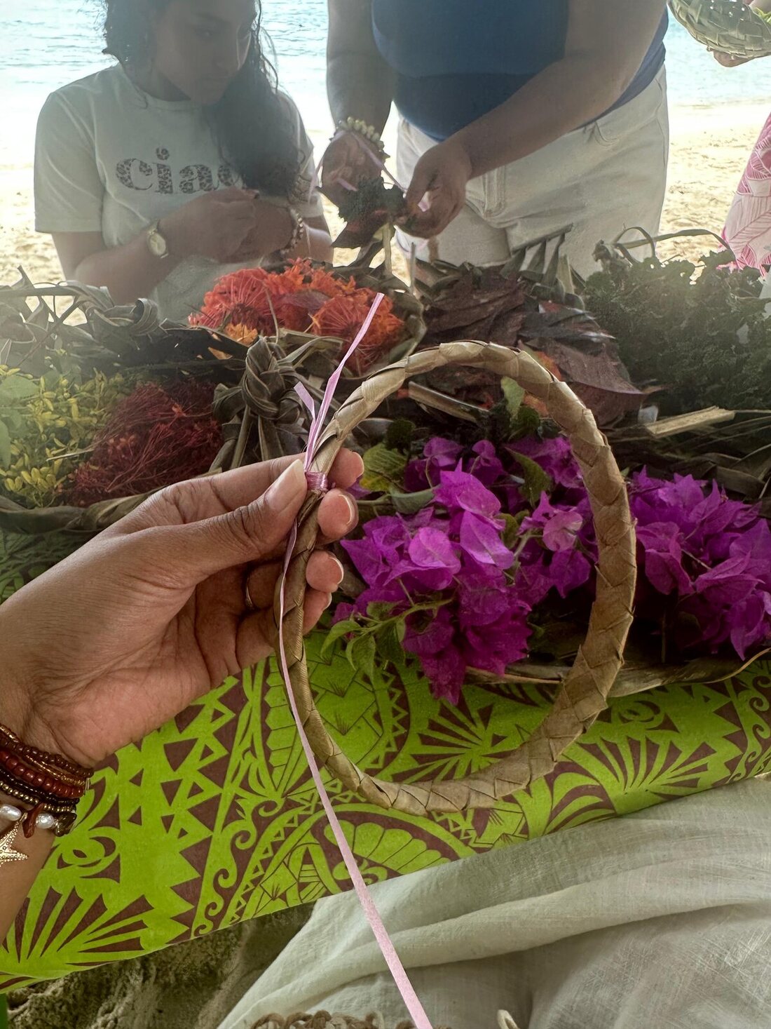 Base de couronne tressée tenue au-dessus des fleurs fraîches pendant un atelier — ORIHERE Activity